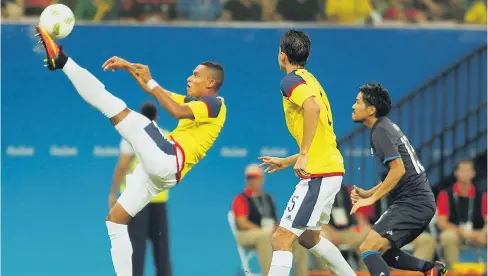  ?? EFE ?? El zaguero barranquil­lero William Tesillo despeja una pelota , su compañero Aguilar lo observa ante la mirada de un futbolista japonés.