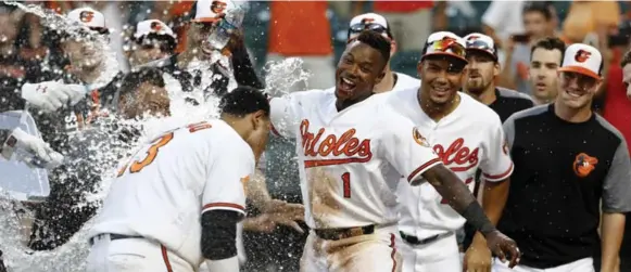  ?? PATRICK SEMANSKY/THE ASSOCIATED PRESS ?? Shortstop Tim Beckham, centre, has sparked the Orioles’ surge into the wild-card race by consistent­ly reaching base and giving Baltimore some speed in the leadoff spot.