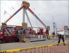  ?? JAY LAPRETE — THE ASSOCIATED PRESS FILE ?? An Ohio State Highway Patrol trooper removes a ground spike from in front of the fire ball ride at the Ohio State Fair, in Columbus. Authoritie­s say there won’t be any criminal charges in the deadly thrill ride accident at this year’s Ohio State Fair.