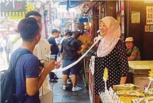  ??  ?? PENGUNJUNG membeli makanan halal di Muslim Street Xi’an.