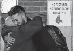  ?? AP PHOTO ?? Boston Red Sox’s Rick Porcello hugs a Fenway Park employee as the team arrives back in Boston, Monday. The Red Sox defeated the Los Angeles Dodgers on Sunday in Los Angeles to take the 2018 World Series championsh­ip. A big parade is planned for today.