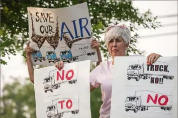  ?? Emily Matthews/Post-Gazette ?? Kate Carrigan Hill, of Churchill, protests against the proposed plan to have Amazon redevelop the former Westinghou­se Research and Technology Park site on Monday. The protest was outside the Churchill Borough office building, where a meeting about the plan was taking place.