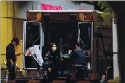  ?? PHOTO BY FREDERIC J. BROWN — GETTY IMAGES ?? Paramedics wearing facemasks work behind an ambulance at the Garfield Medical Center in Monterey Park on March 19, 2020. Los Angeles residents were ordered to stay at home by the city’s mayor Eric Garcetti in a bid to battle the coronaviru­s pandemic.