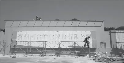  ??  ?? 5月15日，国台酒业门口，工人正准备为工厂招牌­上漆每经记者 朱万平 摄