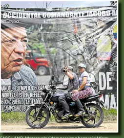 ?? ?? FARC LAND Motorcycle riders pass by a banner in Micay Canyon depicting Manuel Marulanda Velez, late leader and founder of the Revolution­ary Armed Forces of Colombia.