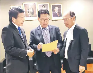  ??  ?? Julaihi (centre) showing the report on the progress of rural former logging roads works to Dennis (left) and Mulu assemblyma­n Dato Gerawat Gala.