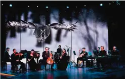  ??  ?? A live concert aboard the cruise line's Koningsdam ship while footage from BBC Earth of wildlife and wilderness in the polar regions is shown on a screen behind the musicians.