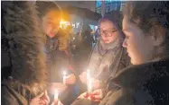  ?? JUSTIN MERRIMAN/THE WASHINGTON POST ?? Mourners gather on Saturday night in Pittsburgh’s Squirrel Hill neighborho­od near the Tree of Life Synagogue.