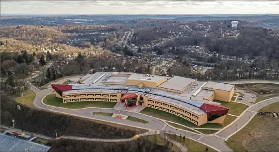  ?? Andrew Rush/Post-Gazette ?? Penn Hills High School as seen on Friday. The district is about $172 million in debt and in the beginnings of state-ordered financial recovery status. Architects at AI insisted on a white roof for the high school instead of a cheaper black one, so that the building would look like a bird from above.