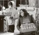  ?? Jason Fochtman / Staff photograph­er ?? Whitney Vasquez places items into a truck during the YMCA’s Mobile Market Food Drive last month.