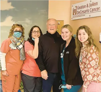  ?? COURTESY ?? Chuck Mulligan smiles with the staff at Geaton & JoAnn DeCesaris Cancer Institute, who cared for him during his radiation treatment for his reoccuring cancer at Luminis Health Anne Arundel Medical Center. Mulligan, 80, of Annapolis, continued weightlift­ing training while going through cancer treatment at Luminis. He has internatio­nal and national powerlifti­ng accolades and is competing in a competitio­n in Columbia at the end of the month.