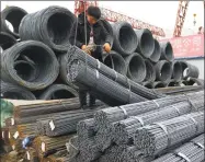  ?? Associated Press ?? A worker loads steel products onto a vehicle at a steel market in Fuyang in central China’s Anhui province.