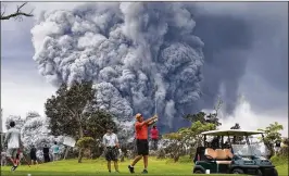  ??  ?? People play golf as an ash plume rises in the distance from the Kilauea volcano on Hawaii’s Big Island. The U.S. Geological Survey said a recent lowering of the lava lake at the volcano’s Halemaumau crater “has raised the potential for explosive...