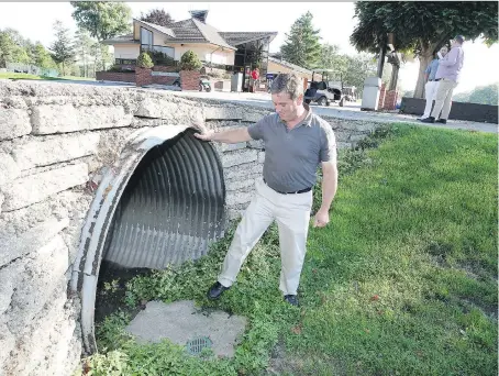  ?? NICK BRANCACCIO ?? Phil Roberts, general manager at Roseland Golf and Curling Club, checks a culvert Wednesday that connects the old Lennon Drain on the ninth hole. Constructi­on will begin shortly on a project to bring water back to the Donald Ross designed course.