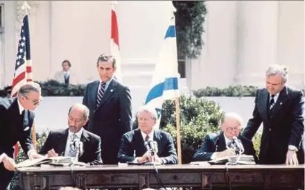  ?? AFP PIC ?? Then Egyptian president Anwar al-Sadat (seated left) and then Israeli premier Menachem Begin (seated right) signing the historic United States-sponsored peace treaty between Israel and Egypt at the White House on March 26, 1979. Seated between them is then US president Jimmy Carter.