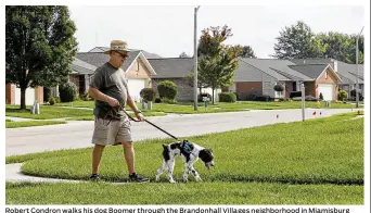  ?? CHRIS STEWART / STAFF ?? Robert Condron walks his dog Boomer through the Brandonhal­l Villages neighborho­od in Miamisburg where residentia­l property values rose on average 28.5 percent. Condron said the tax value of his home jumped $43,000. Home values in Montgomery County on...