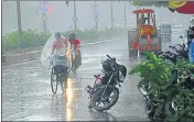  ?? HT PHOTO ?? Commuters braving rain in Prayagraj on Sunday.