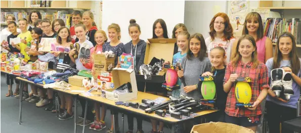  ?? [LIZ BEVAN / THE OBSERVER] ?? Grade 6 students from Wellesley Public School wrote nearly 100 letters to local businesses and community members, asking for their help in fighting hidden poverty. The letters were successful, gathering plenty of items for donation to local families...