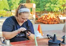  ??  ?? Bekah Wade works on decoration­s Wednesday as setup continues for Friday’s opening of Pumpkinvil­le at the Myriad Gardens in downtown Oklahoma City.