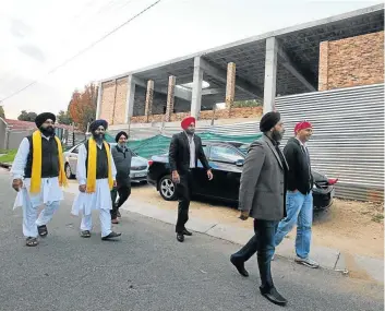  ?? Picture: SIMON MATHEBULA ?? IN STEP: Members of the Sikh community inspect the progress of building works at the temple site in Sandton