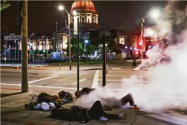  ?? Gabrielle Lurie / The Chronicle 2019 ?? “One of the most beautiful cities on the planet”: Four men sleep on Larkin Street across from City Hall.