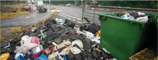  ??  ?? A bit of a tip: Rubbish is piled up along the road in Plymouth where the travellers have set up their illegal camp