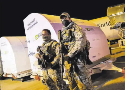  ?? AMANDA PEROBELLI / REUTERS ?? Guardias ante contenedor­es con vacunas, en el aeropuerto brasileño de Viracopos, en Campinas.