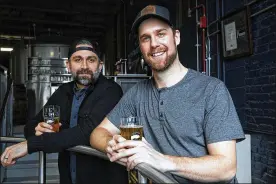  ?? ERIN HOOLEY PHOTOS / CHICAGO TRIBUNE ?? Blackhawks defenseman Calvin de Haan (right) and Goose Island’s T.J. Annerino share a beer at Goose Island Brewery in Chicago. The two have worked together on creating a specialty beer for charity.