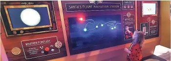  ?? AP ?? In this Monday, November 21 photo, Sophie Golding checks Santa’s route at Santa’s Flight Academy in Great Lakes Crossing Outlets in Auburn Hills, Michigan.