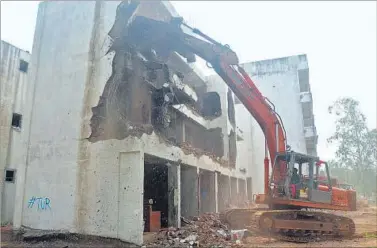  ?? PHOTOS: BACHCHAN KUMAR ?? A bulldozer demolishes one of the four buildings in Bhagwat Pada in Ada village of Panvel on Wednesday. (Right) A cop keeps guard as officials carry out demolition work.