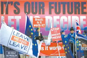  ?? Xinhua-Yonhap ?? Pro- and anti-Brexit protesters hold flags and placards outside the Parliament in London, Britain, Monday. British Prime Minister Theresa May said she was against delaying Britain’s exit from the European Union, insisting the March 29 departure date was still her target.