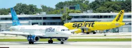 ?? AP ?? A JetBlue Airways Airbus A320 (left) passes a Spirit Airlines Airbus A320 as it taxis on the runway at the Fort Lauderdale­Hollywood Internatio­nal Airport in Fort Lauderdale, Florida. JetBlue and Spirit Airlines are appealing a judge’s ruling that is blocking their planned merger.