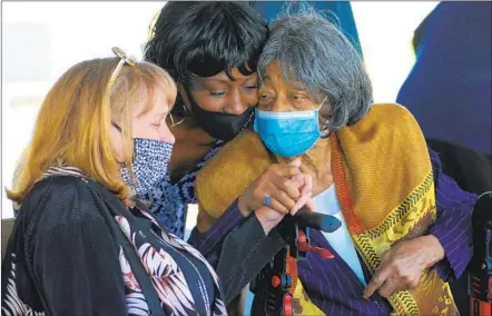  ?? NELVIN C. CEPEDA U-T ?? Dainaie Hilbert (center) gives her grandmothe­r, Ruby Vryes-price (right) a hug at the memorial for Trunnell Levett Price at New Seasons Church in Spring Valley on Saturday. Price’s wife, Michele, holds Vryes-price’s hand.