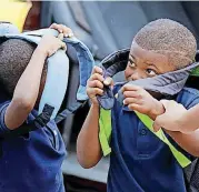  ??  ?? Eryk King, 4, left and Kenneth Ezell, 6, wear their new backpacks at the beginning of the first day of school Tuesday at Thelma Parks Elementary School in Oklahoma City.