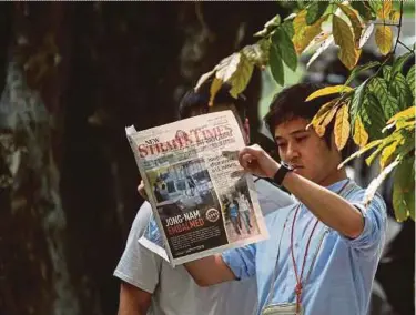  ?? PIC
EPA ?? A foreign journalist reading the latest exclusive on the Jong-nam case in yesterday’s edition of the ‘New Straits Times’. The newspaper has been among the sources of reference for coverage on the highprofil­e murder.