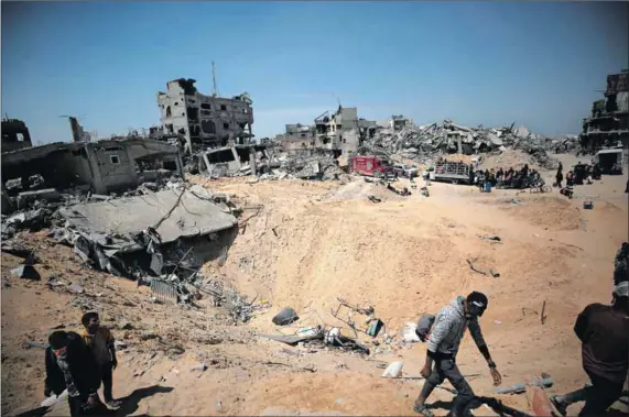  ?? Photos: Yasser Qudaih/getty Images & Dawoud Abo Alkas/getty Images ?? Destructio­n: Palestinia­n families (above) return to their homes after Israeli forces withdrew from Khan Yunis, Gaza. Jamil al-fayoumi (left), who lost three sons in Israeli attacks on his neighbourh­ood, lives in a makeshift shelter next to the rubble of his house in Gaza City.