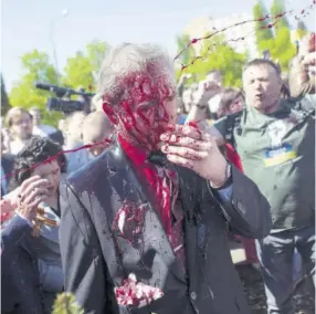 ?? (Photos: AP) ?? Russian Ambassador to Poland Ambassador Sergey Andreev is covered with red paint in Warsaw, Poland, on Monday. Protesters threw red paint on the Russian ambassador as he arrived at a cemetery in Warsaw to pay respects to Red Army soldiers who died during World War II.