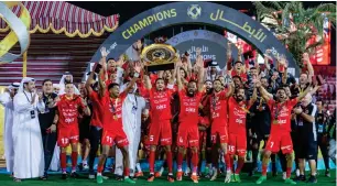  ?? — X ?? Shabab Al Ahli players celebrate with the trophy.