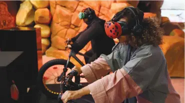  ?? (Faisal Al Nasser/Reuters) ?? VIRTUAL BIKE RIDERS experience a 3-D presentati­on on the planned city of Neom during an exhibition in Riyadh last October.