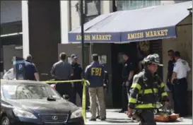  ?? MARK LENNIHAN — THE ASSOCIATED PRESS ?? Emergency personnel work in lower Manhattan after a carbon monoxide leak Tuesday, June 13, 2017, in New York. Authoritie­s ultimately traced the problem Tuesday morning to a broken boiler pipe in the grocery store basement.