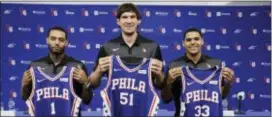  ?? MATT ROURKE — THE ASSOCIATED PRESS ?? From left to right, Sixers’ Mike Scott, Boban Marjanovic, and Tobias Harris pose for photograph­s during a news conference Thursday at the team’s practice facility in Camden.
