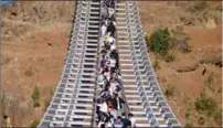  ?? SHI DIE / FOR CHINA DAILY ?? People from Weining, Guizhou, walk across a bridge that replaced a zip line to reach Huize county, in Yunnan province, on Jan 22.