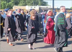  ?? DAN SOKIL — MEDIANEWS GROUP ?? North Penn school board members wave as they walk into the high school’s Crawford Stadium, with the district transporta­tion center in the background, for the high school graduation on June 14, 2023.