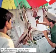  ??  ?? An Uighur vendor cuts meat at a street market in Kashgar, Xinjiang province