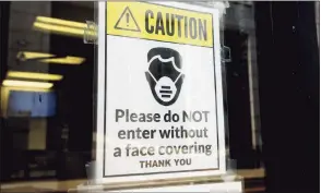  ?? Ned Gerard / Hearst Connecticu­t Media ?? A sign requiring masks or face coverings hangs on the front door of the Morton Government Center in Bridgeport on Aug 11.