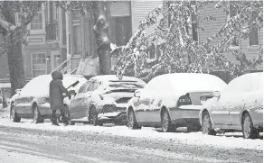  ?? GRACE HAUK/ USA TODAY ?? A woman wipes the snow off her car in Chicago on Tuesday.