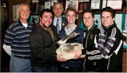  ?? Contribute­d ?? The KSS boys curling team uses their collective strength to hoist the heavy trophy they brought back from Smithers. The trophy will reside at the Kelowna Curling Club.