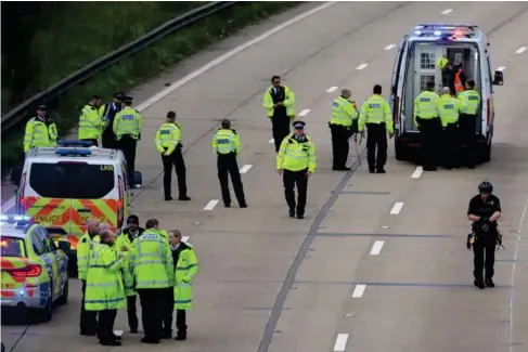  ?? (Getty) ?? Officers escort an activist fo ll owing a demonstrat­ion on the M25 ear l ier in the week