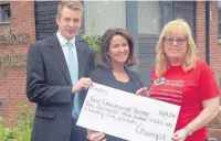  ??  ?? Carl Taylor, funeral director, and managing director Lianna Champ hand over the donation to hospice fundraiser Denise Gee