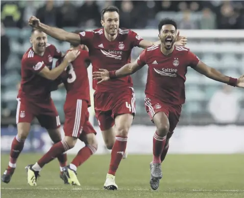  ??  ?? 0 The Aberdeen players, led by Shay Logan, right, and Andrew Considine race to celebrate with goalie Joe Lewis after the final kick.